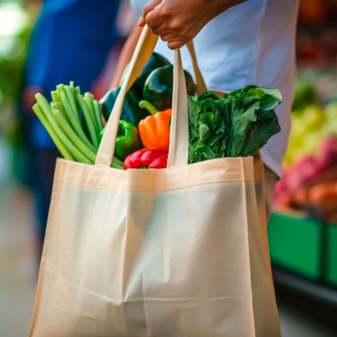 Eine mit frischem Gemüse vom Markt prall gefüllte Einkaufstasche.
