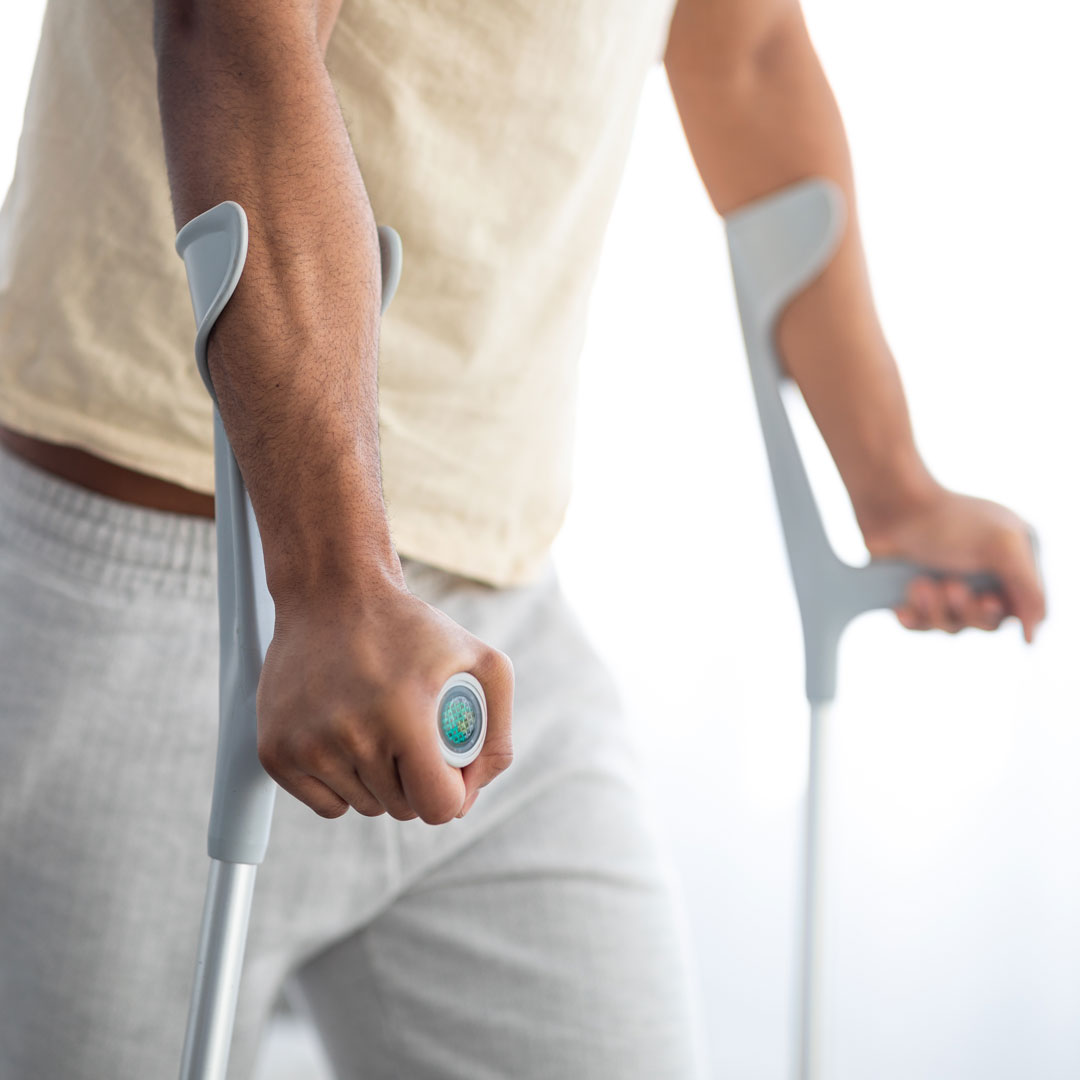 Arme, die sich auf Krücken stützen.